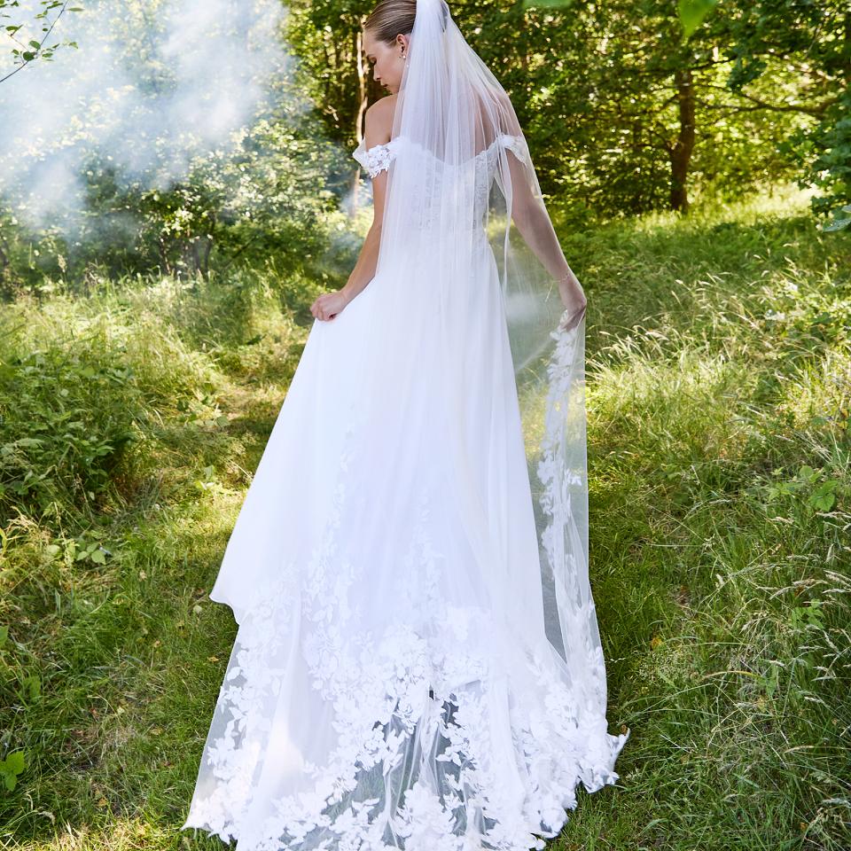 Weichfliessendes Lilly Brautkleid mit offshoulder Ärmeln und romantische Schleppe